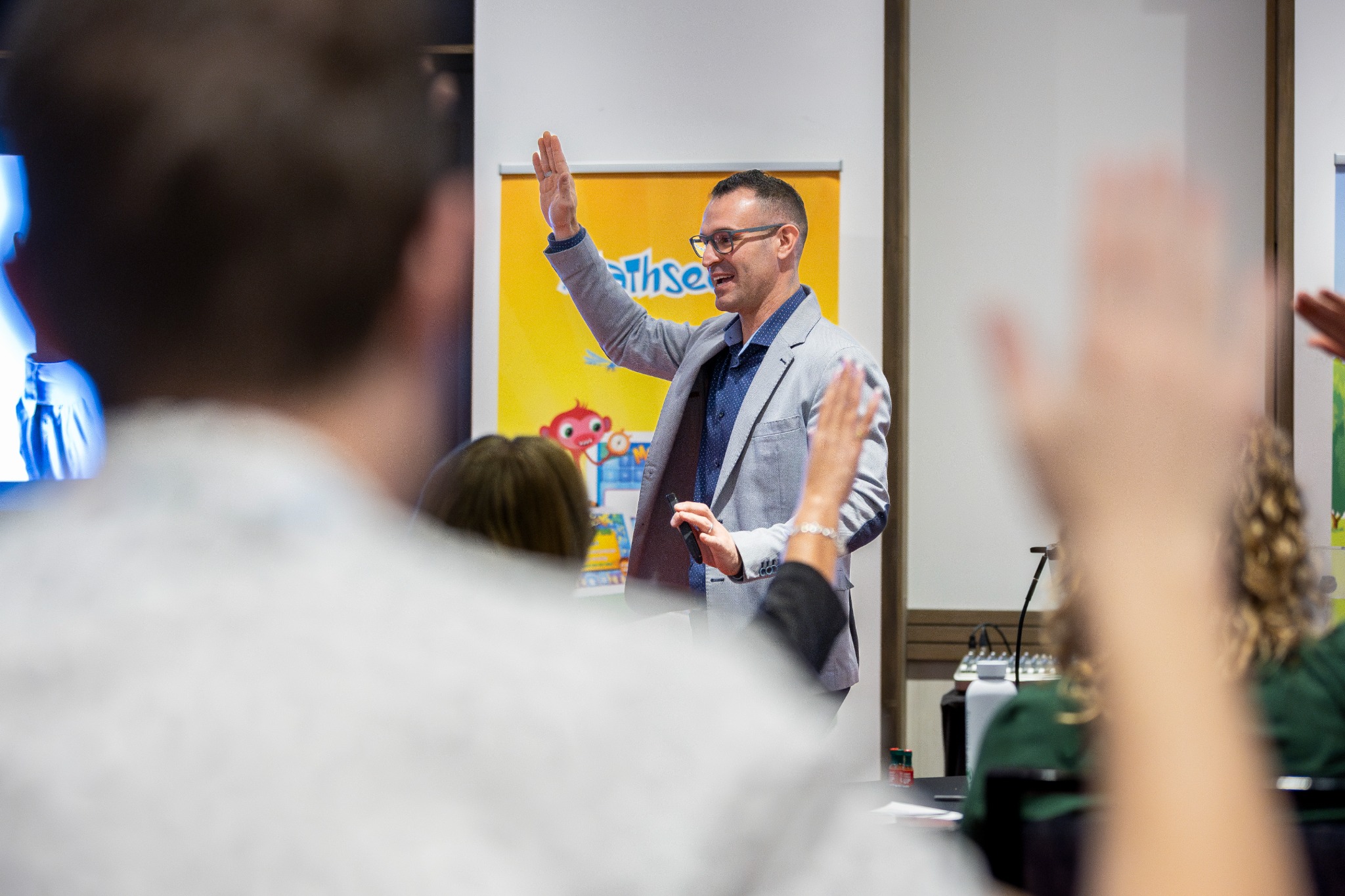 Giancarlo Brotto invites participation as educators raise their hands during a session.